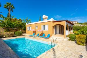 a villa with a swimming pool in front of a house at Villa Lela Pente in Peyia