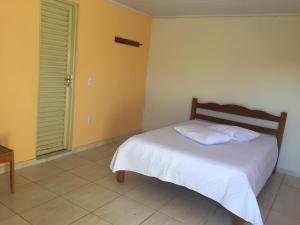 1 dormitorio con 1 cama con 2 almohadas en Pousada Catarinense, en Chapada dos Guimarães