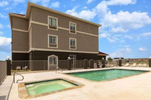 a building with a swimming pool in front of a house at La Quinta by Wyndham Bridgeport in Bridgeport