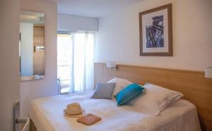 ein Schlafzimmer mit einem Bett mit Hut darauf in der Unterkunft Résidence Pierre & Vacances Les Bulles de Mer in Saint-Cyprien