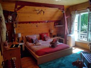 a bedroom with a bed in a wooden room at O tour du monde in Cellettes