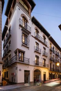 een wit gebouw met balkons in een straat bij Santa Escolástica en pleno centro de Granada in Granada