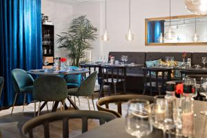 un restaurant avec des tables et des chaises et des verres à vin dans l'établissement Palm Tree Hotel, Best Western Signature Collection, à Trelleborg