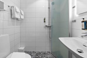 La salle de bains est pourvue d'une douche, de toilettes et d'un lavabo. dans l'établissement Palm Tree Hotel, Best Western Signature Collection, à Trelleborg