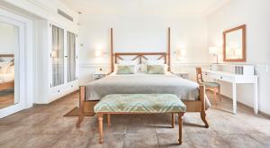 a bedroom with a bed and a desk and a chair at Insotel Punta Prima Prestige Suites & Spa in Punta Prima +50 photos