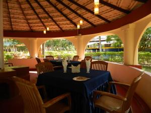 a dining room with a blue table and chairs at Fantasy Golf Resort in Devanhalli
