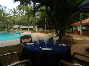 a table with a blue table cloth and a pool at Fantasy Golf Resort in Devanhalli