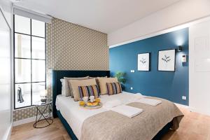 um quarto com uma cama grande e uma parede azul em Urban House by LovelyStay em Porto