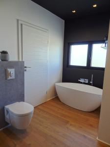 a bathroom with a large tub and a toilet at Luxueuse propriété SAINT CIRICE aux vues aériennes in Cahors