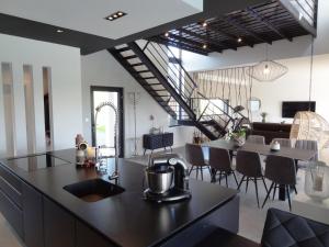 een keuken en een woonkamer met een tafel en stoelen bij Luxueuse propriété SAINT CIRICE aux vues aériennes in Cahors