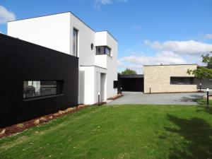 een wit huis met een zwarte gevel en een tuin bij Luxueuse propriété SAINT CIRICE aux vues aériennes in Cahors