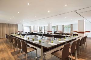 Best Western Premier CMC Girona في جيرونا: غرفة طعام كبيرة مع طاولة وكراسي طويلة