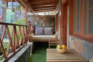 a porch with a bench and a bowl of fruit at Redondo de Guayedra in Guayedra