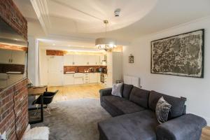 a living room with a couch and a kitchen at Spacious, Elegant City Centre Apartment with FREE WIFI in Nottingham