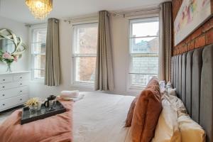 a bedroom with a large bed and two windows at Spacious, Elegant City Centre Apartment with FREE WIFI in Nottingham