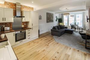 a kitchen and living room with a couch and a table at Spacious, Elegant City Centre Apartment with FREE WIFI in Nottingham +14 photos