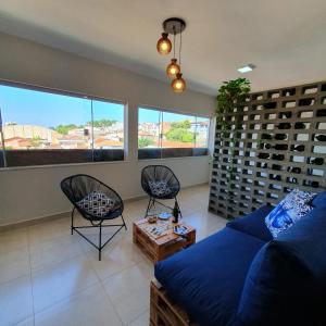 a living room with a couch and chairs and wine racks at Casa Romão I - Charme perto de Vinícola e Centro in Espirito Santo Do Pinhal +5 photos
