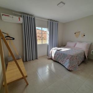 a bedroom with a bed and a window at Casa Romão I - Charme perto de Vinícola e Centro in Espirito Santo Do Pinhal