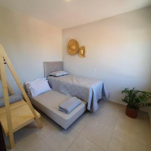 a small bedroom with a bed and a ladder at Casa Romão I - Charme perto de Vinícola e Centro in Espirito Santo Do Pinhal