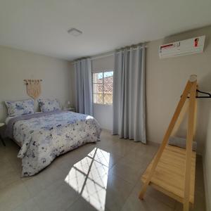 a bedroom with a bed and a window at Casa Romão I - Charme perto de Vinícola e Centro in Espirito Santo Do Pinhal