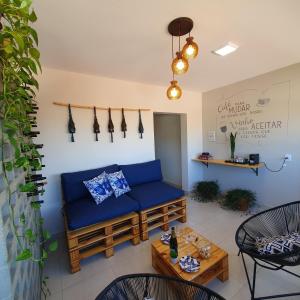 a living room with a blue couch and a table at Casa Romão I - Charme perto de Vinícola e Centro in Espirito Santo Do Pinhal