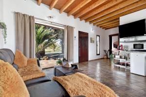 - un salon avec un canapé et une grande fenêtre dans l'établissement Casa Guenia I, à Teguise