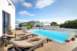 - une piscine avec chaises longues sur la terrasse dans l'établissement Casa Guenia I, à Teguise