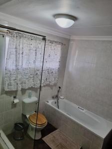 łazienka z wanną, toaletą i wanną w obiekcie The Noble Dew Guest House w mieście Newcastle