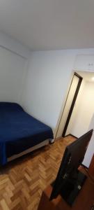 1 dormitorio con cama y mesa con ordenador portátil en Departamento Subte linea B Ángel Gallardo en Buenos Aires