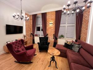 a living room with red furniture and a brick wall at Brick Castle - Apartament Helga in Wrocław