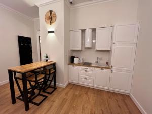a kitchen with a table and a clock on the wall at Brick Castle - Apartament Helga in Wrocław