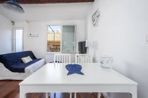 a white living room with a table and a couch at Au cœur du Panier avec terrasse 2 à 4 personnes climatisation in Marseille