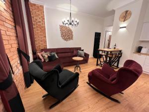 a living room with a couch and two chairs at Brick Castle - Apartament Helga in Wrocław