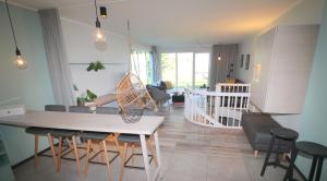 cocina y sala de estar con mesa y sillas en Design-Apartment am Plöner See, en Ascheberg