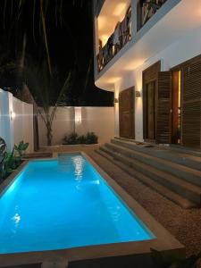 a swimming pool in front of a house at night at Lala salama Kendwa villas in Kendwa