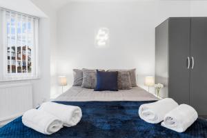 een slaapkamer met een groot bed en handdoeken bij 4 Bedroom House Near BHX, NEC & HS2 in Birmingham
