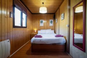 1 dormitorio con 1 cama en una cabaña de madera en Casa Rural La Canadiense Log Cabin en Buenache de la Sierra