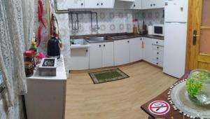 una cucina con armadietti bianchi e pavimenti in legno di Guest House Capitan Meca ad Alicante