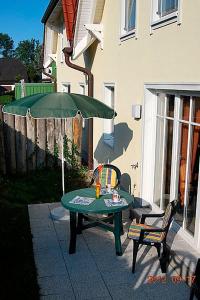 ツィングストにあるSonnenwinkel, FW 2の緑のテーブルと椅子、傘