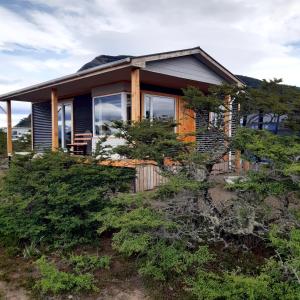a house on top of a hill with trees at Cabañas Sierra Dorotea in Puerto Natales