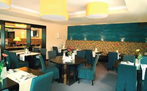 un comedor con mesas y sillas azules en Moselhotel & Restaurant Zur Traube GmbH, en Löf