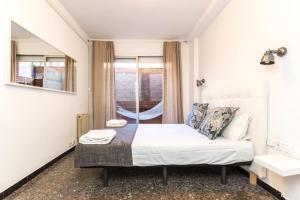 een kleine slaapkamer met een bed en een raam bij Find Calm at this cozy City Sanctuary with terrace in Barcelona