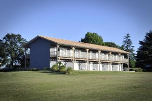 a large building with a large lawn in front of it at La Petite Couronne, Ecolodge & Lofts in Saint-Cricq-Chalosse