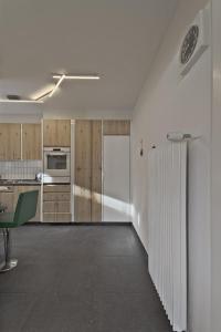 a kitchen with white walls and wooden cabinets at Chesa Chavriol - Samedan in Samedan