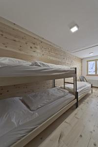 two bunk beds in a room with a wooden wall at Chesa Chavriol - Samedan in Samedan