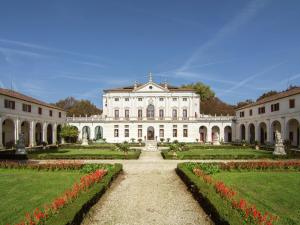 un grande edificio bianco con giardino e fiori di Historic Venetian Style Castle in Piombino Dese with Pool a Piombino Dese