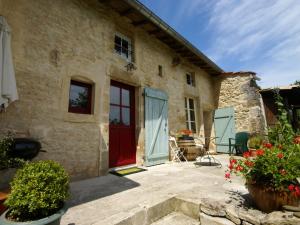 una casa in pietra con una porta rossa e dei fiori di Stunning Holiday Home with Fenced Garden, Garage,BBQ,Heating a Seigneulles