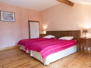 ein Schlafzimmer mit einem großen Bett mit einer rosa Decke in der Unterkunft Stunning Holiday Home with Fenced Garden, Garage,BBQ,Heating in Seigneulles