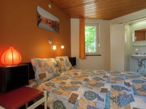 a bedroom with a bed and a lamp and a window at Attractive holiday home in Stoumont with garden in Stoumont