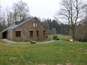 a stone house in a field with a yard at Attractive holiday home in Stoumont with garden in Stoumont